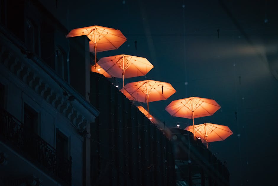 Lit umbrellas at night symbolizing protection and style